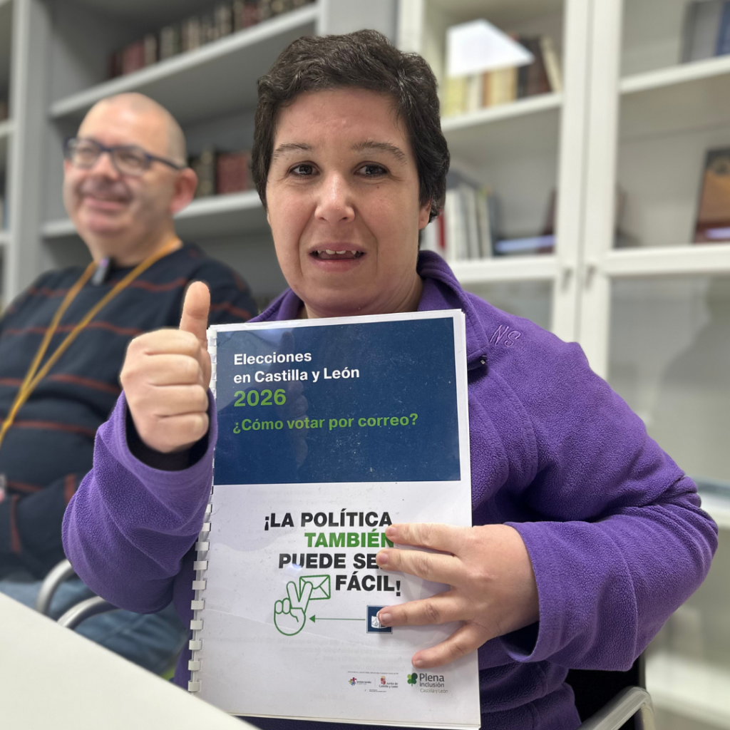 Mujer sujeta un manual de voto por correo en lectura fácil mientras levanta con otra mano el pulgar